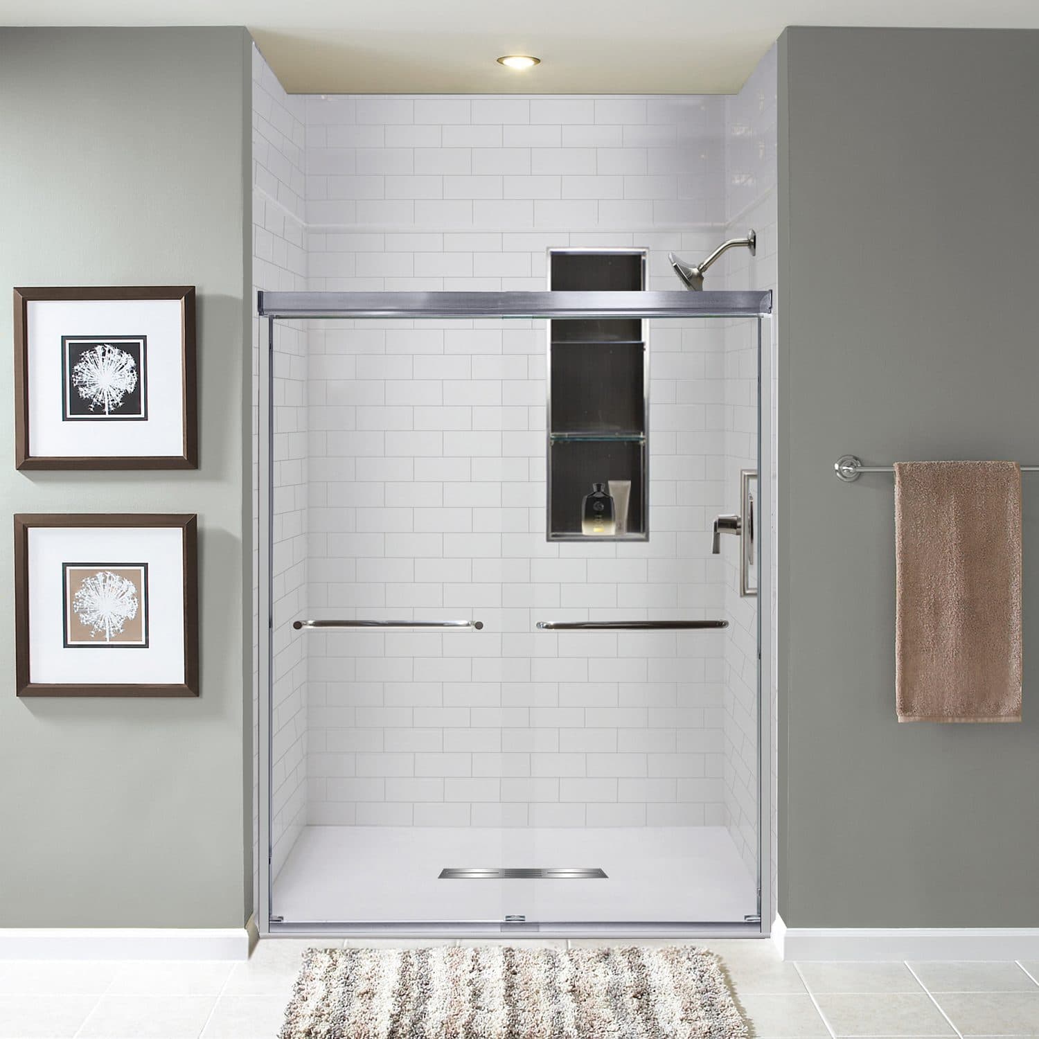 Walk-in shower with a white 3 by 8 subway tile pattern in solid surface, behind a chrome sliding door